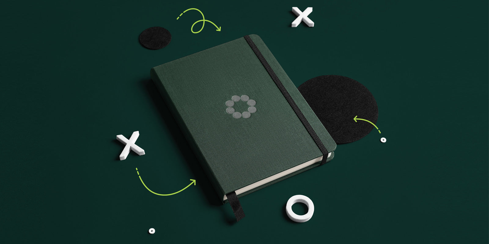 Dark green Huddle Men's Journal on green background with X and O sport markers