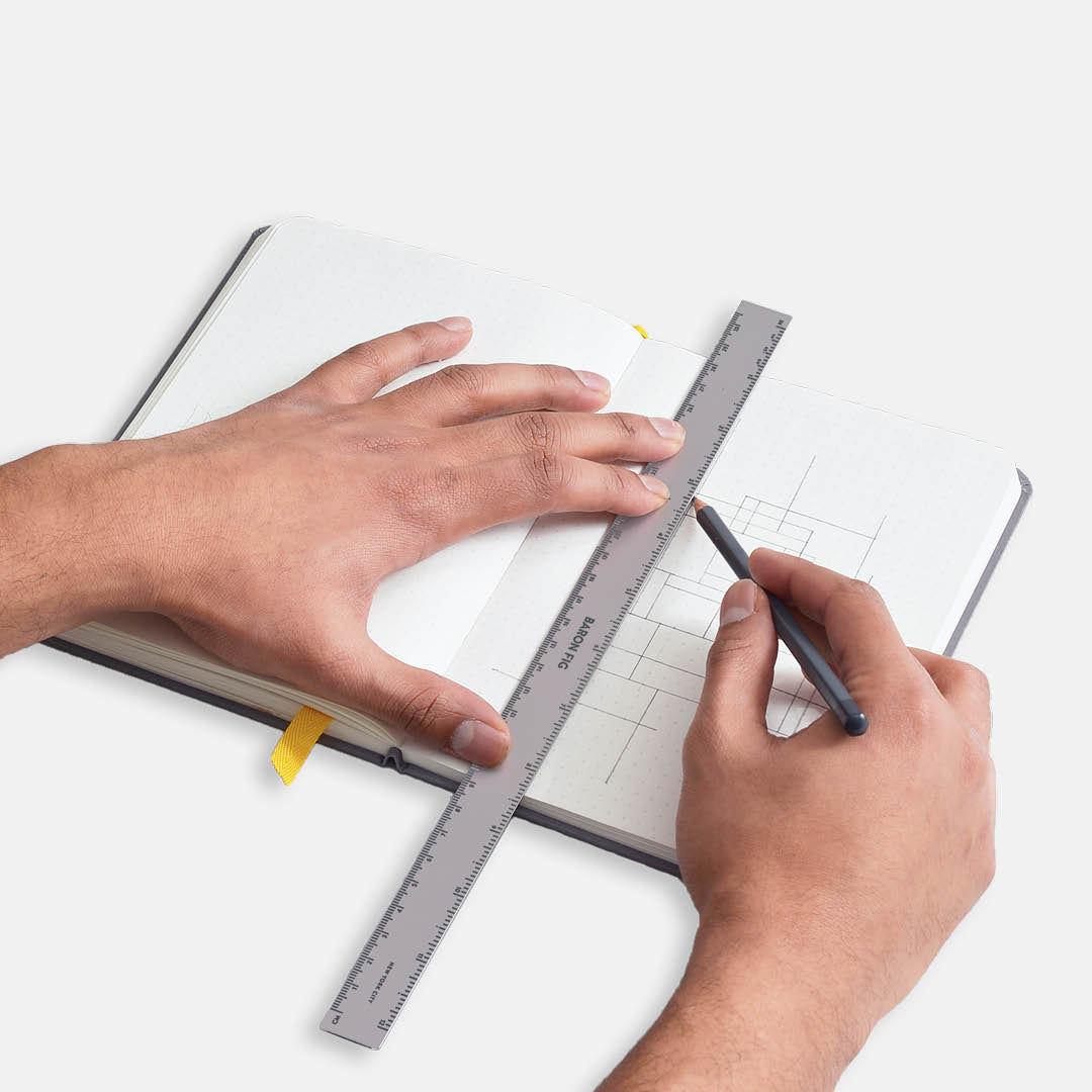 Long ruler being used to draw in Confidant notebook